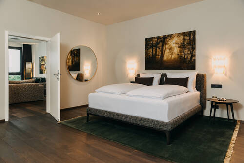 Schlafzimmer des Penthouse mit offener Tür zum Wohnbereich.