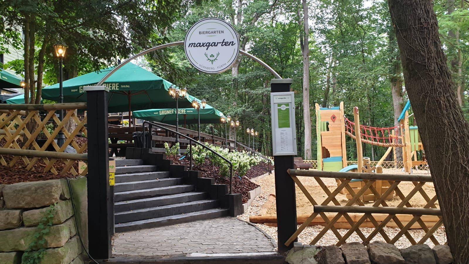 Eingang zum Biergarten mit Spielplatz im Hintergrund.