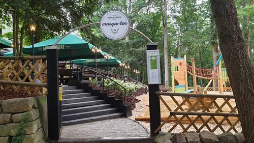 Eingang zum Biergarten mit Spielplatz im Hintergrund.