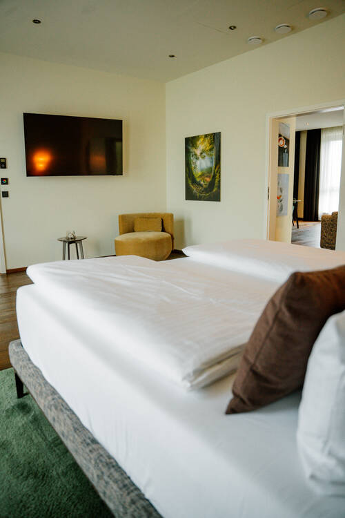 Schlafzimmer mit Bett und TV an der Wand in der Suite.