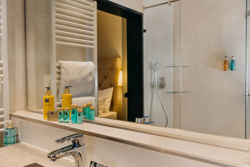Blick in den Spiegel des Bades der Junior Suite Bad inkl. Dusche.