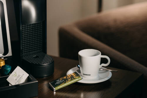 Detailaufnahme Nespresso-Kaffeemaschine und Espressotasse mit Schokolade.