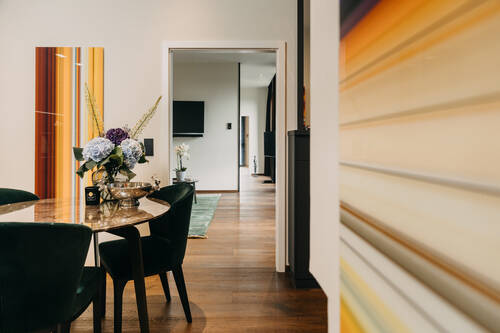 Blick durch den Essbereich in das Schlafzimmer der Suite.