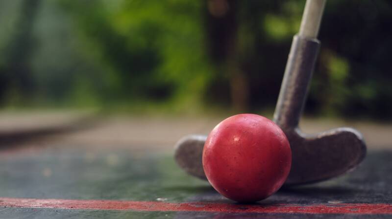 Minigolf-Schläger und Ball beim Putten.