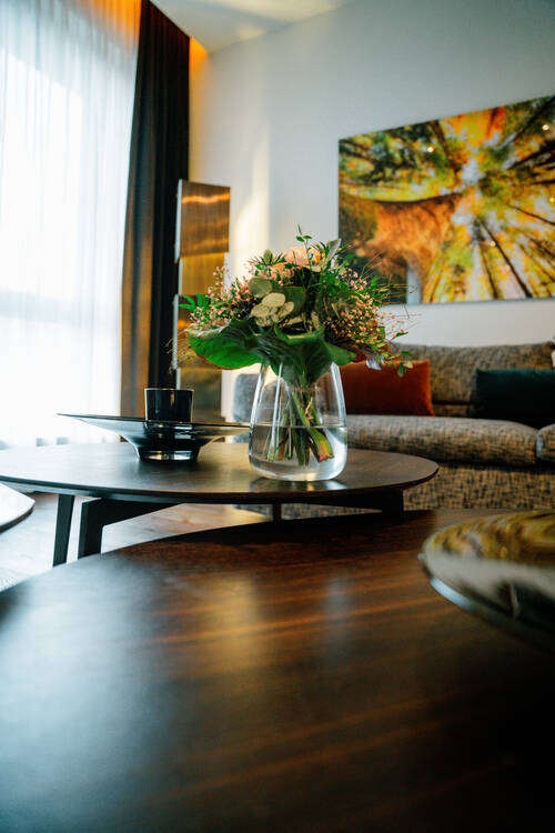 Detailaufnahme mit Blumenstrauß im Wohnzimmer der Suite.