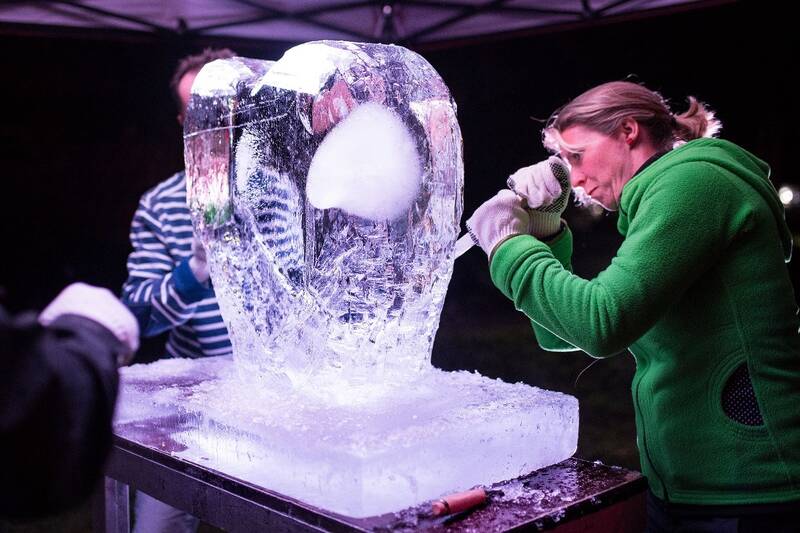 A woman carves an ice sculpture.