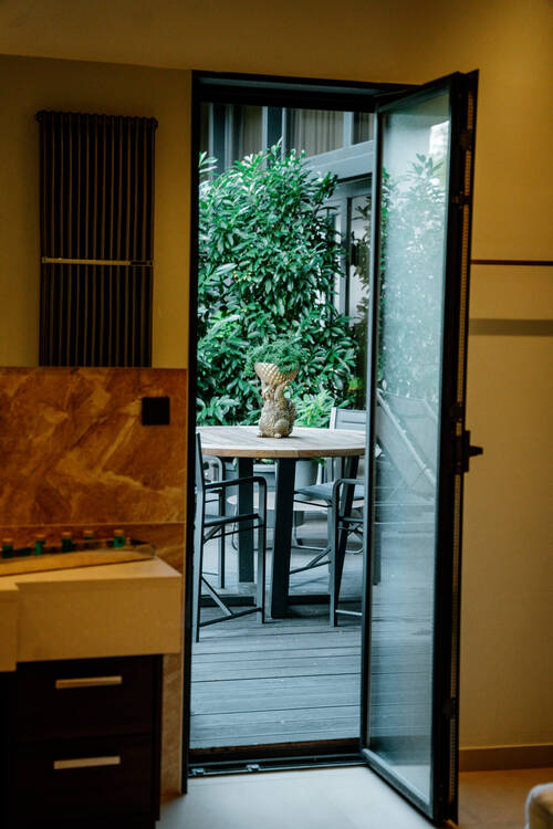 Blick auf den begrünten Balkon durch das große Badezimmer.