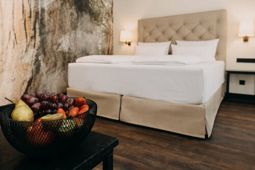 Nahaufnahme Obstschale auf einem Tisch vor dem Bett der Junior Suite.