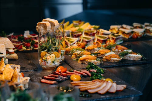 Close-up of a coffee break with sandwiches and cold cuts.